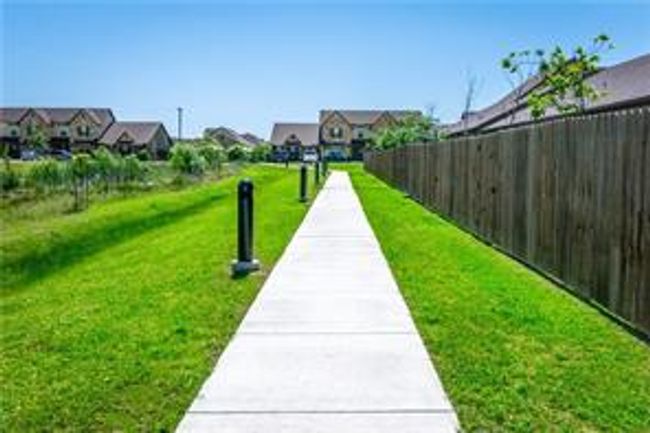 View of property's community featuring a lawn, fence, and a residential view | Image 26