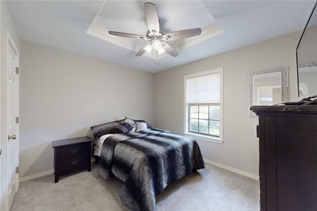Bedroom with light colored carpet, baseboards, and a raised ceiling | Image 14