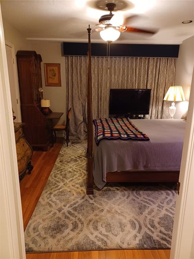 Looking out of the water closet with the tub/shower at your back. There is a shelf with several glass shelves adjacent to the toilet. | Image 18