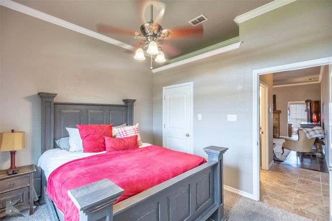Bedroom featuring crown molding, baseboards, light carpet, and ceiling fan | Image 20