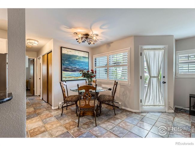 Dining area with a unique, one-of-a-kind chandelier, new windows and elegant plantation shutters | Image 10