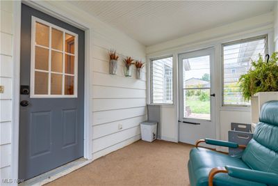 Sitting room with wood walls and light colored carpet | Image 2