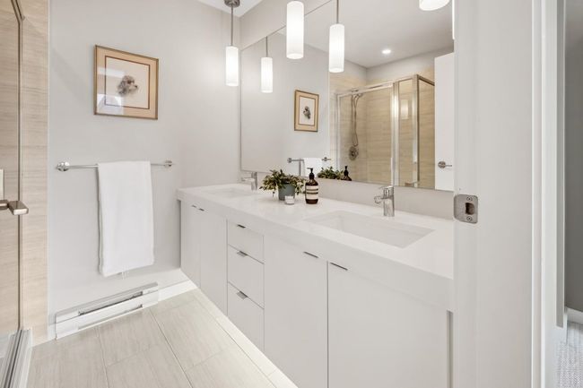Bathroom featuring a shower stall, double vanity, and tile patterned floors | Image 27
