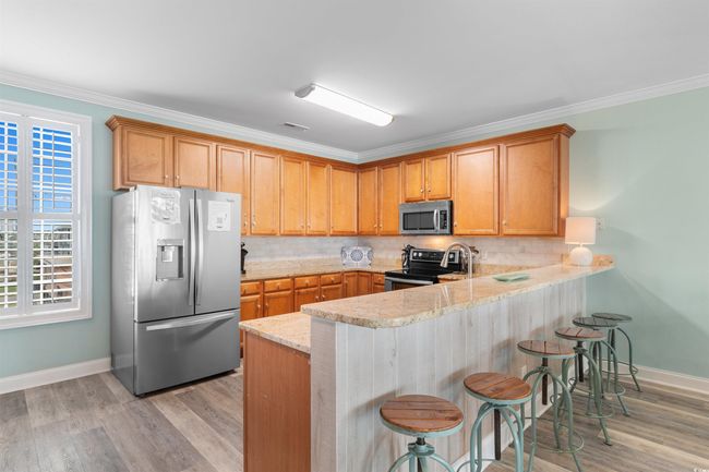 Kitchen featuring stainless steel appliances, a peninsula, backsplash | Image 12