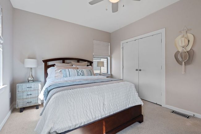 Bedroom featuring light colored carpet, a closet, and a ceiling fan | Image 15