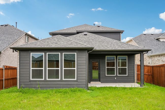 Rear view of house with a shingled roof and a patio | Image 14