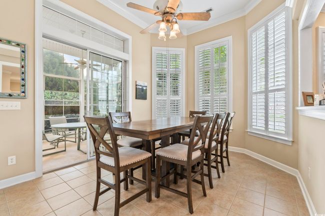 Dining room with ornamental molding, a ceiling fan, light tile patterned floors, and baseboards | Image 9