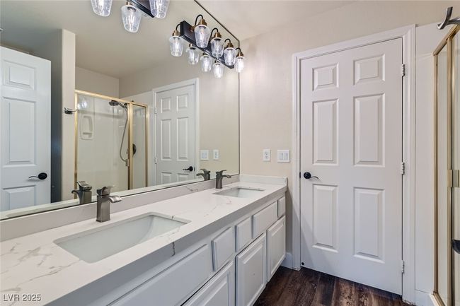 Bathroom with a stall shower, double vanity, and wood finished floors | Image 31