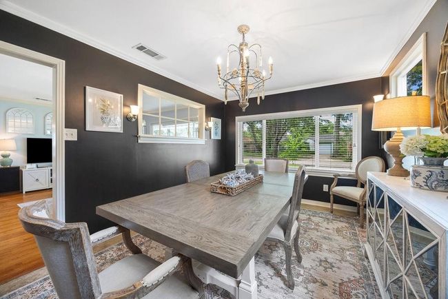 Dining room, with a peek into the living room. Notice the character of the interior window! This allows light to pass through and gives a connected feeling to each defined space. | Image 8