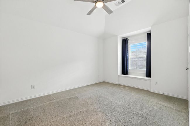 Empty room with carpet floors, lofted ceiling, and ceiling fan | Image 16