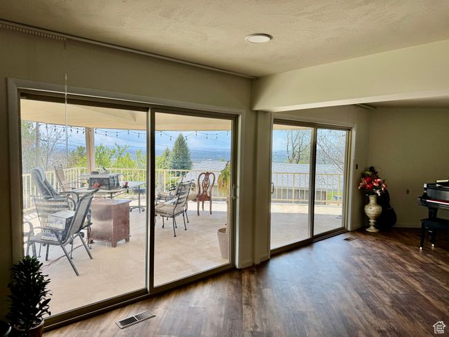 Doorway to outside with a textured ceiling, visible vents, and dark wood finished floors | Image 17