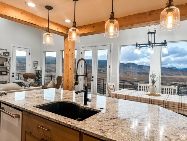 Kitchen featuring a mountain view, open floor plan, beam ceiling, and a sink | Image 13