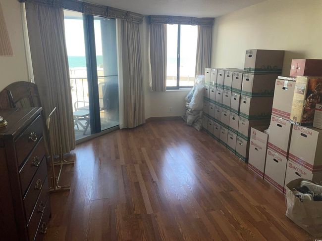 Spare room with a beach view, wood finished floors, and a water view | Image 14