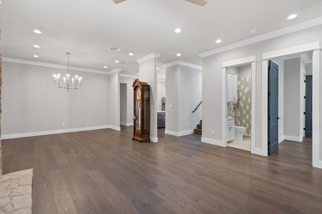 Unfurnished living room featuring dark wood finished floors, stairs, visible vents, and recessed lighting | Image 6