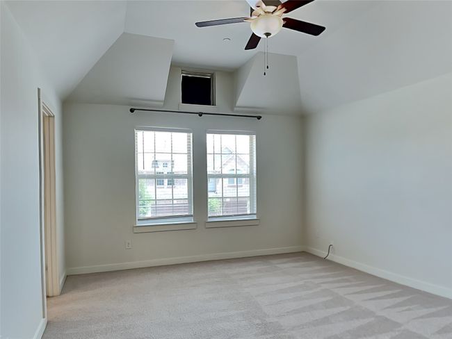Unfurnished room with light carpet, a ceiling fan, baseboards, and high vaulted ceiling | Image 6