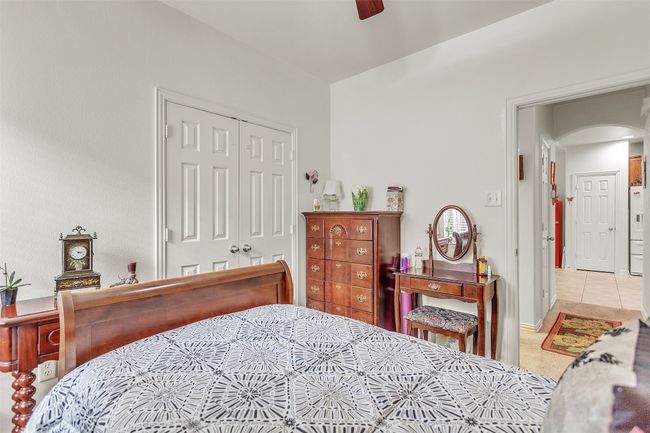 Bedroom with arched walkways, a closet, a ceiling fan, and light colored carpet | Image 14