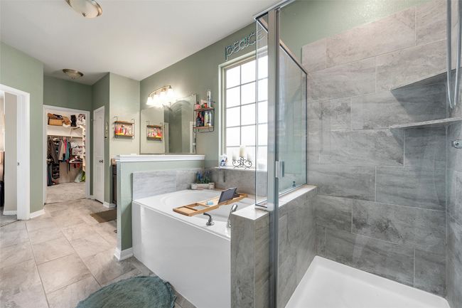Bathroom featuring a stall shower, a bath, and a spacious closet | Image 19