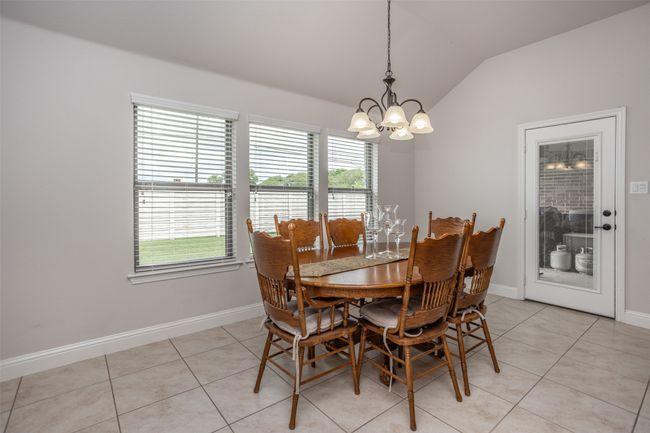 Dining room featuring vaulted ceiling, a chandelier, and light tile patterned floors | Image 19
