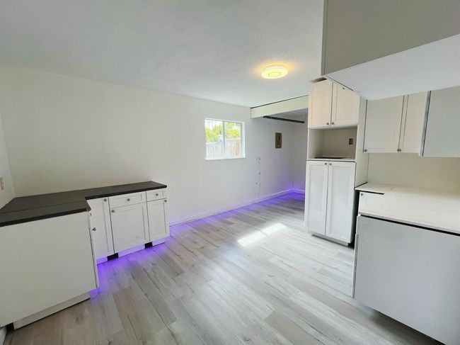 Kitchen with light wood-style flooring and white cabinets | Image 9