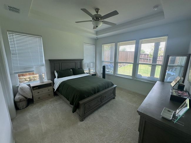 Carpeted bedroom featuring a raised ceiling and a ceiling fan | Image 8
