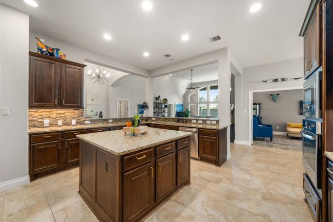 This alternate view of the beautiful kitchen showcases the beautiful rich cabinetry and granite countertops with plenty of outlets for all your gadgets. | Image 17