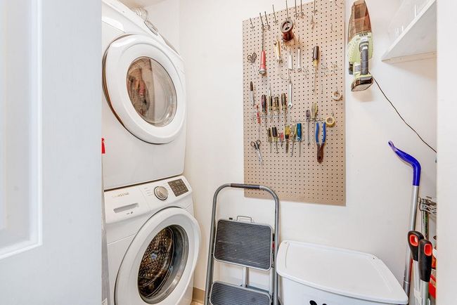 Laundry area featuring stacked washing machine and dryer | Image 8