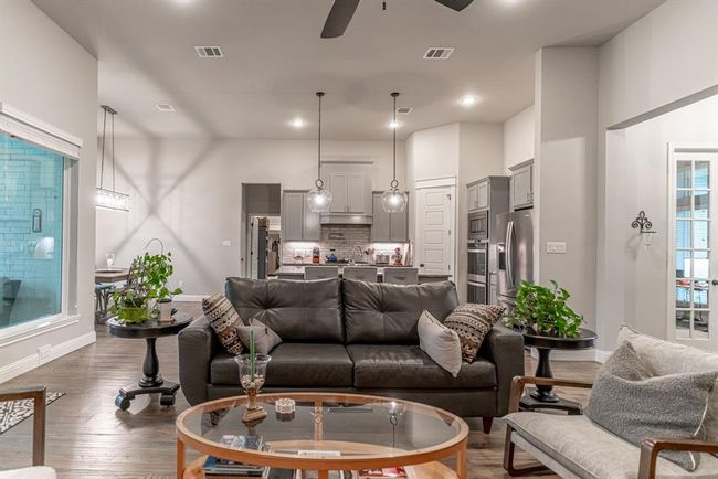 Kitchen featuring wood-type flooring, appliances with stainless steel finishes, a stone fireplace, and sink | Image 13