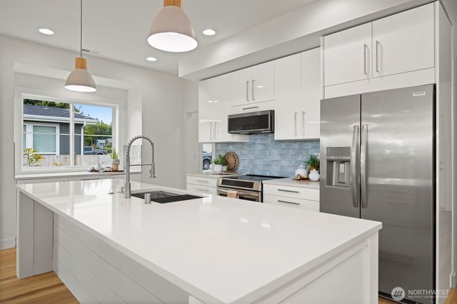 Another view of this beautiful, sleek kitchen with the gorgeous blue tile backsplash that mimics the water. | Image 12