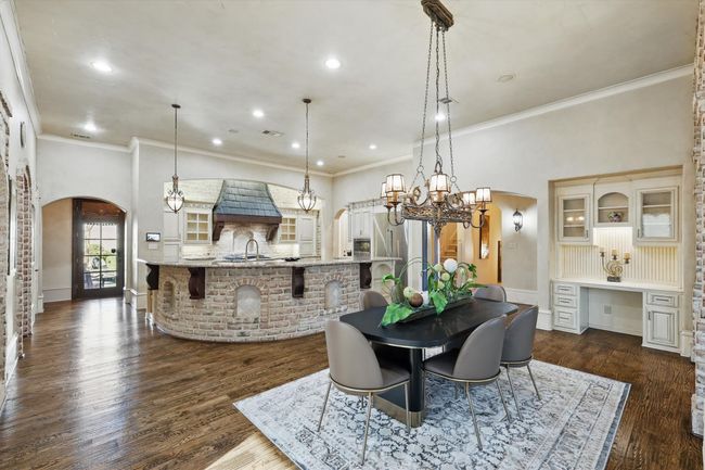 The casual dining space has a fireplace and built in desk area. | Image 15