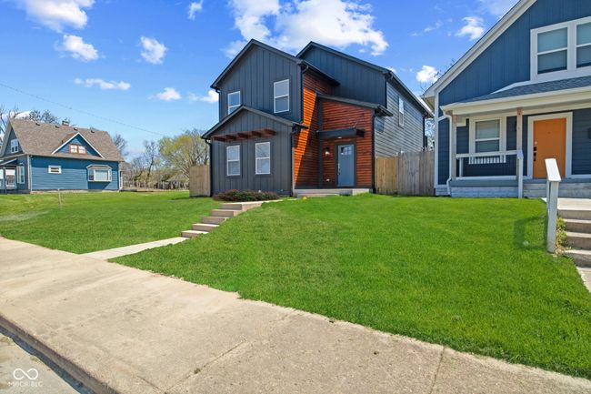 modern home featuring board and batten siding, fence, and a front yard | Image 4