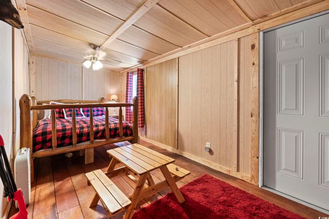 Bedroom with wooden ceiling, hardwood / wood-style floors, and wood walls | Image 17