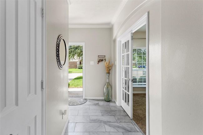 Bright, welcoming entryway with tiled floors and neutral walls. | Image 8