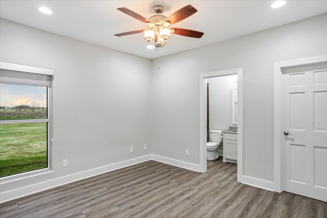 Unfurnished bedroom with ensuite bath, ceiling fan, and wood-type flooring | Image 26