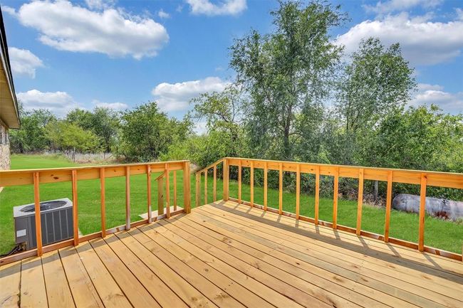 Wooden deck featuring central air condition unit and a lawn | Image 42