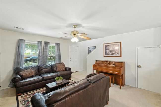 Living room with light colored carpet and ceiling fan | Image 7