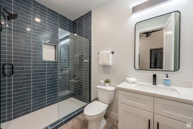 Bathroom featuring wood-type flooring, toilet, walk in shower, and vanity | Image 41