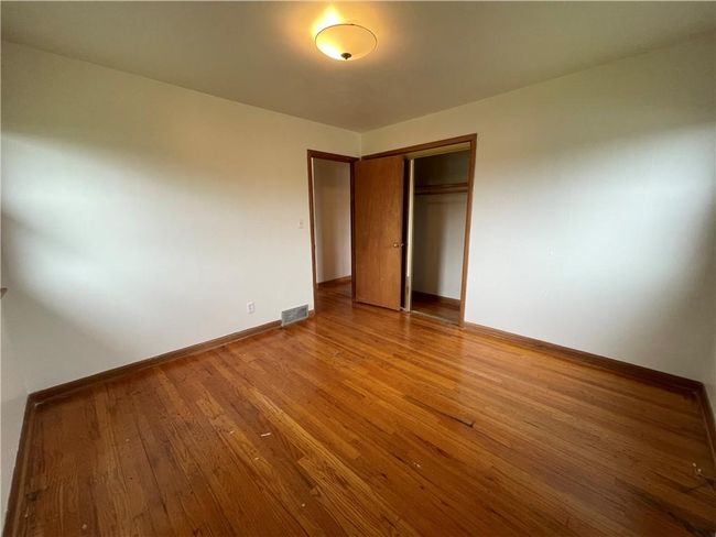 Unfurnished bedroom featuring a closet, visible vents, wood finished floors, and baseboards | Image 13