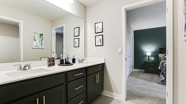 Jack and Jill bath has dual sinks in a shared space, separated by a door to the tub/shower and stool space. | Image 30