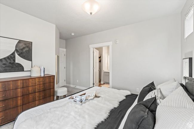 Carpeted bedroom featuring baseboards and connected bathroom | Image 6