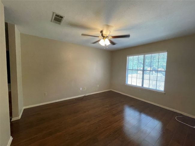 Empty room with baseboards, ceiling fan, and dark wood-style flooring | Image 23