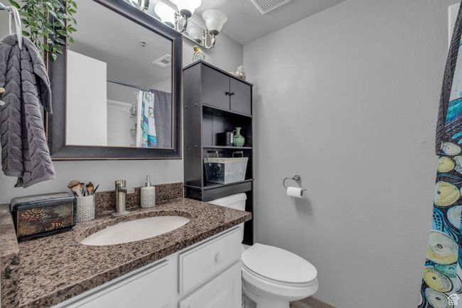 Bathroom with visible vents, toilet, vanity, and a shower with curtain | Image 14