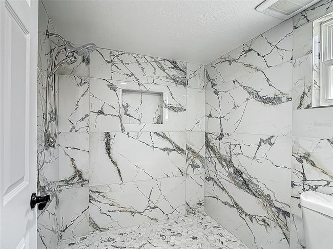 Primary shower, newly tiled with multiple shower heads. | Image 26