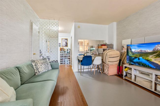 Bedroom with wood finished floors and a wall unit AC | Image 5