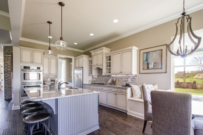 The kitchen includes a built-in microwave and oven tower, gas cook top, and an island with plenty of room for eating. | Image 23