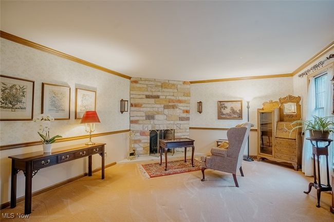 Living room with ornamental molding, carpet flooring, a fireplace, and wallpapered walls | Image 16