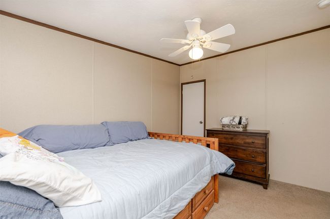 Bedroom featuring light carpet, a decorative wall, crown molding, and ceiling fan | Image 14
