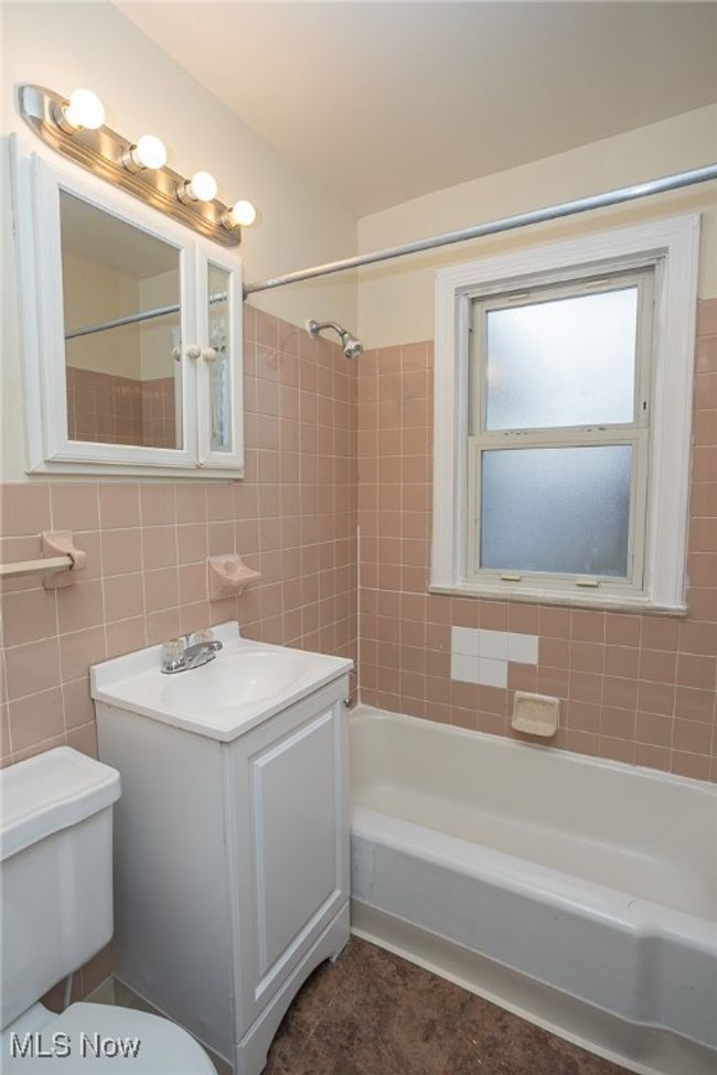 Bathroom featuring vanity, shower / bath combination, tile walls, and tile patterned flooring | Image 15