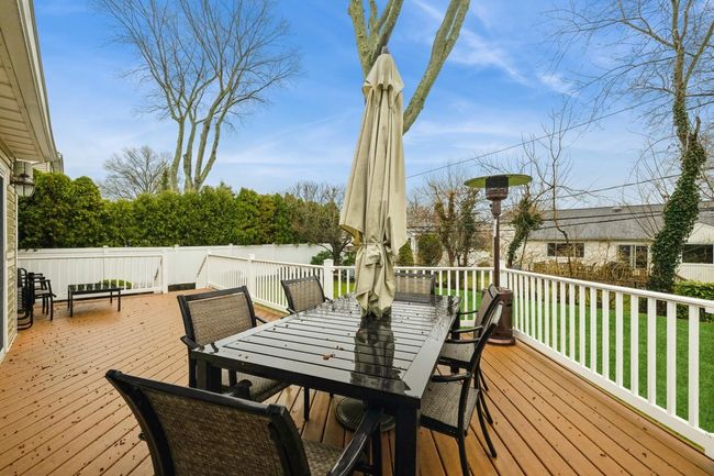 Wooden deck featuring outdoor dining space and a yard | Image 24