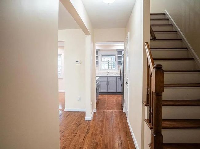 Hall featuring a sink, light wood-type flooring, baseboards, and stairs | Image 5