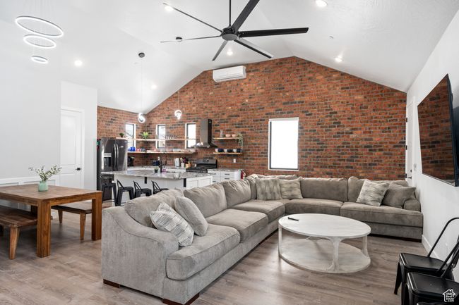 Living room featuring ceiling fan, sink, brick wall, and light wood-type flooring | Image 32